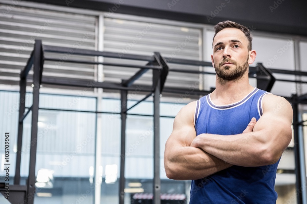 Muscular man standing with arms crossed Muscular man standing with arms crossed