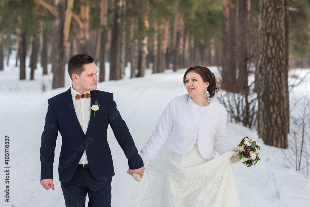 couple newlyweds walking in a winter forest couple newlyweds walking in a winter forest