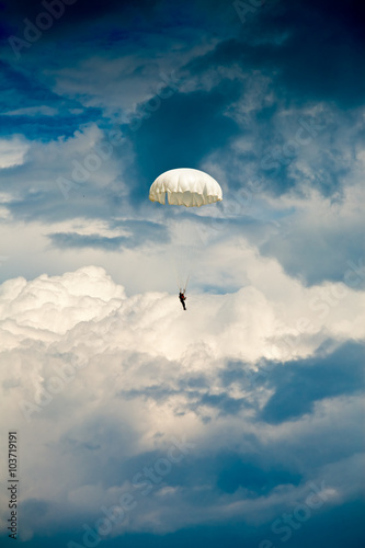 Parachute jumper against dramatic sky