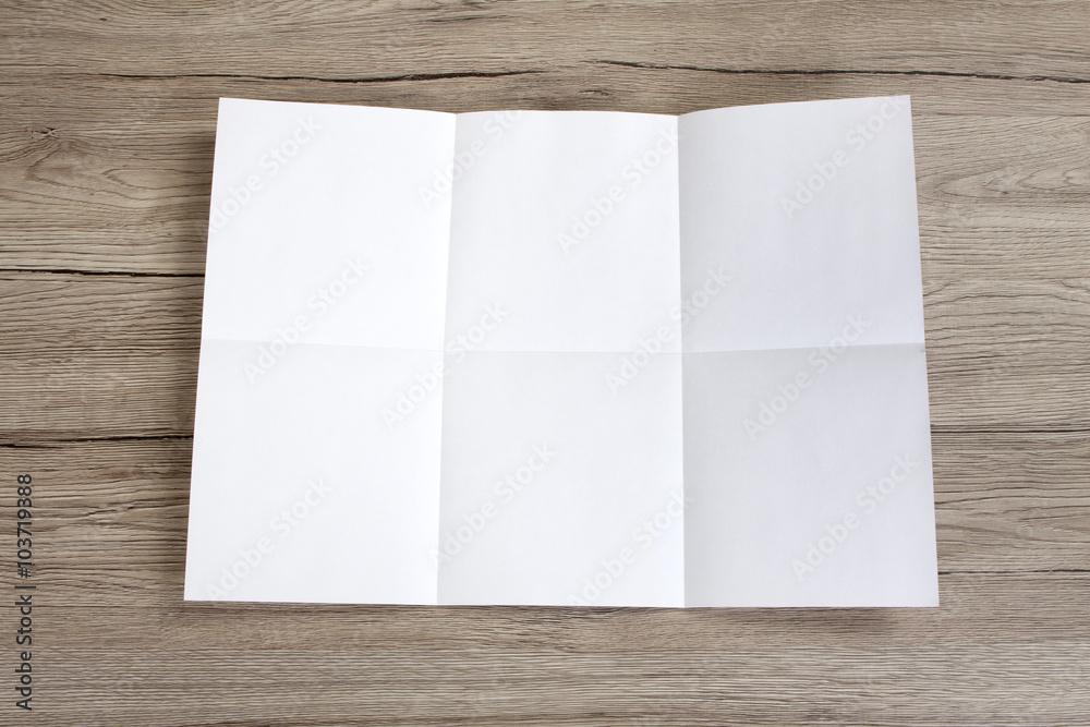 Close up of a crumpled unfolded piece of paper on wooden backgro Close up of a crumpled unfolded piece of paper on wooden backgro
