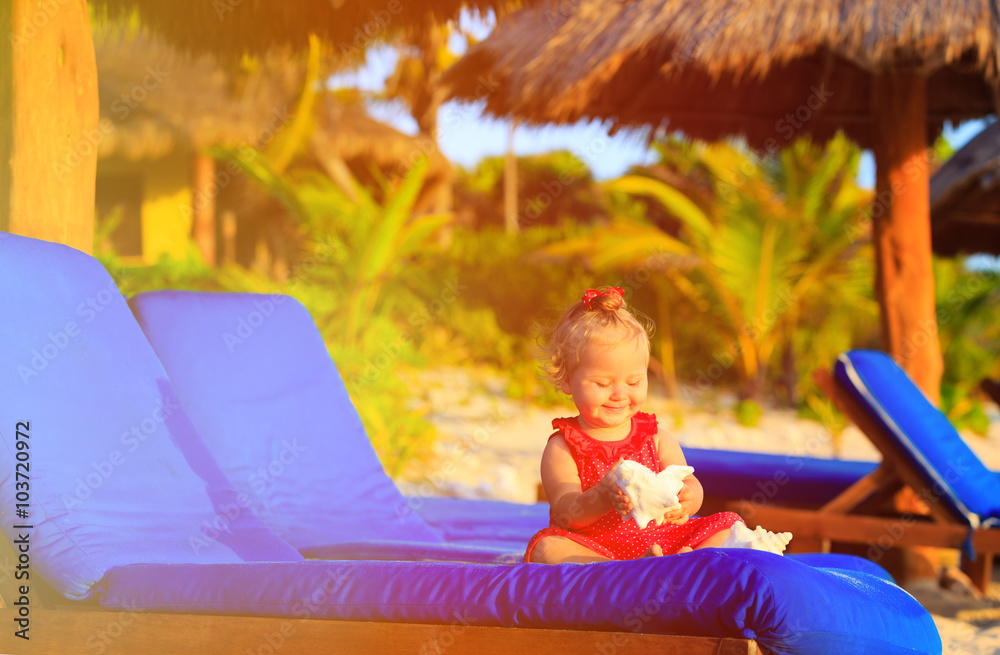 Fototapeta premium cute little baby girl with seashells on tropical beach