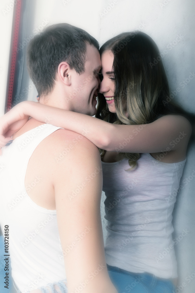 Happy young couple enjoying an intimate moment, laughing a lot and man gently strokes his partner's hair Happy young couple enjoying an intimate moment, laughing a lot and man gently strokes his partner's hair