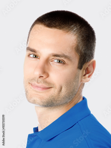 Smiling young attractive man, against grey