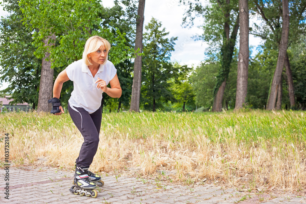 Adult woman in-line skating in a city park for healthy exercise and relaxation