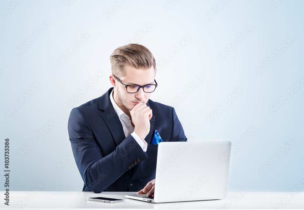 business man, with a serious face working for laptop business man, with a serious face working for laptop
