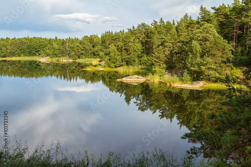 Calm forest lake with reflections in summer.