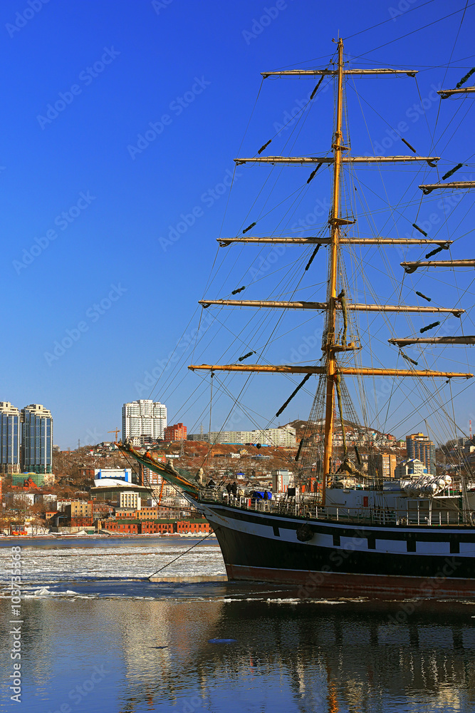 reflection sailing ship and buildings of the city of Vladivostok in winter sea surface reflection sailing ship and buildings of the city of Vladivostok in winter sea surface