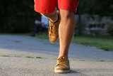 man running legs in park, leather shoes, red shorts