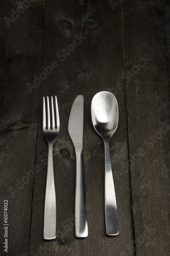 Set di Posate con forchetta, coltello e cucchiaio su tavolo in legno scuro