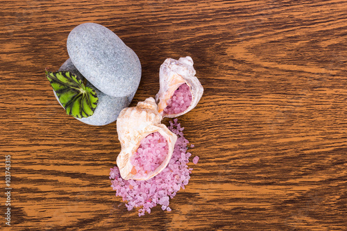 Relax: sea salt of pink color in shells and two stones are on th