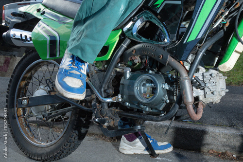 Fototapeta Naklejka Na Ścianę i Meble -  Teenage Boy Bout To Kick Start A Motorbike
