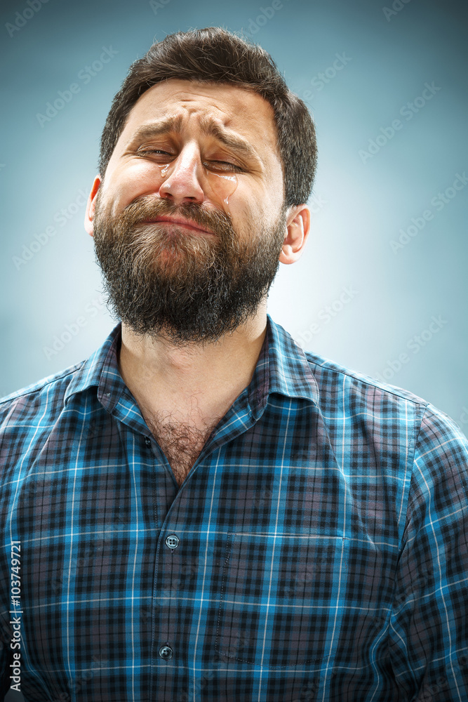 The crying man with tears on face closeup The crying man with tears on face closeup