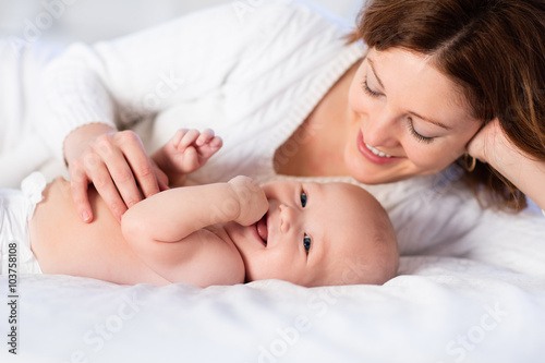 Mother and baby on a white bed