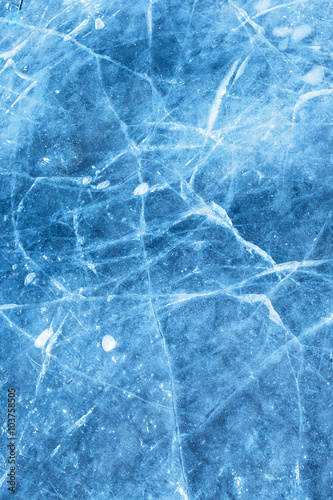 A network of cracks on a piece of blue ice with air bubble.