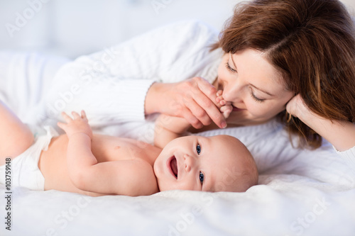 Mother and baby on a white bed