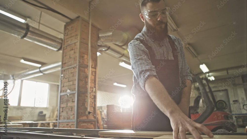 Carpenter at a factory making wooden floor. RAW video record. Carpenter at a factory making wooden floor. RAW video record.