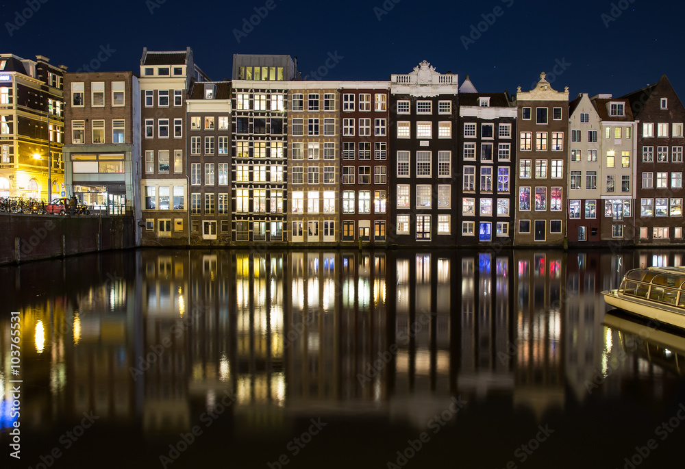 Buildings along the Damrak at Night in Amsterdam