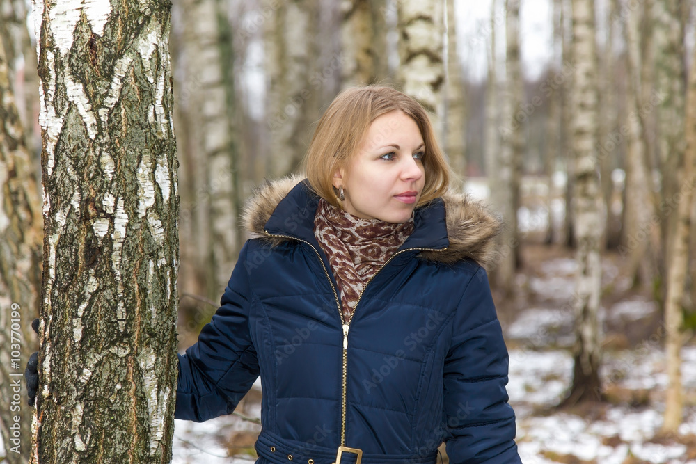 Nice, beautiful young lady walking calmly between birch trees in the park Nice, beautiful young lady walking calmly between birch trees in the park