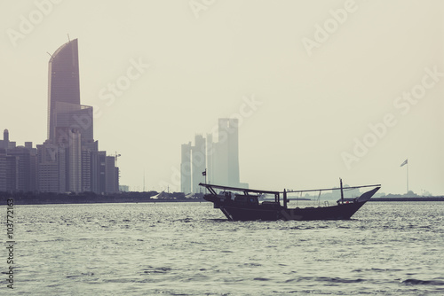 Abu Dhabi buildings skyline with old fishing boat