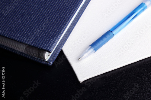 блокнот и ручка на черном фоне
