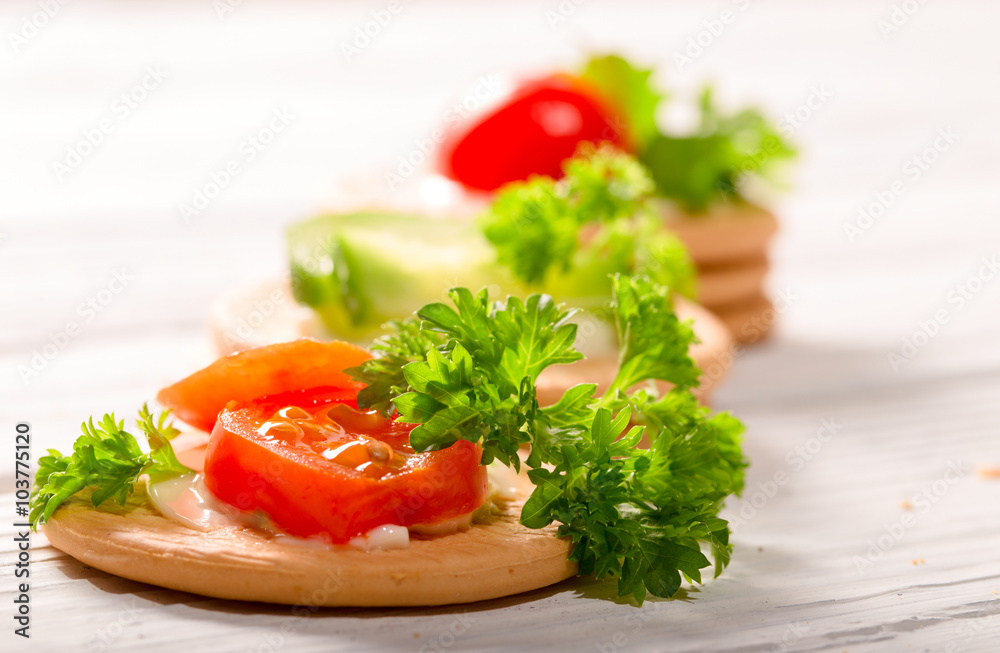 Cheese, tomatoes and greens of parsley on cookies Cheese, tomatoes and greens of parsley on cookies