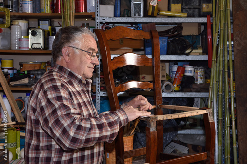 older man restoring a chair