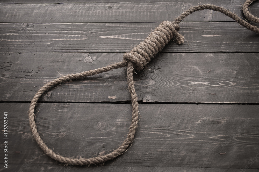 Obraz premium Running knot.Loop hempen ropeon on a dark wood tables background.