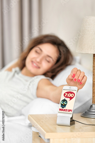 Young woman reaching for sm...