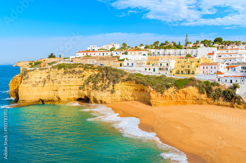 A view of beach with colourful houses in Carvoeiro fishing village, Portugal