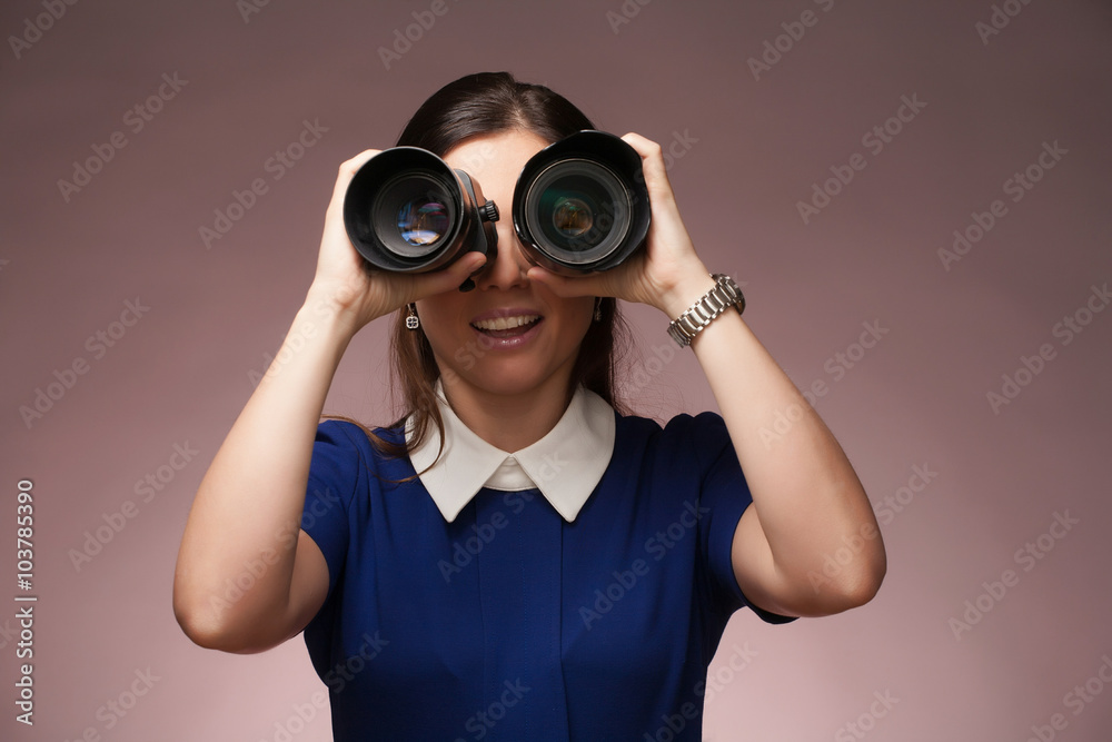 Girl in a blue suit. Makes binocular by two photo lenses. Girl in a blue suit. Makes binocular by two photo lenses.