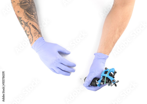 Tattooist hands in blue glo...
