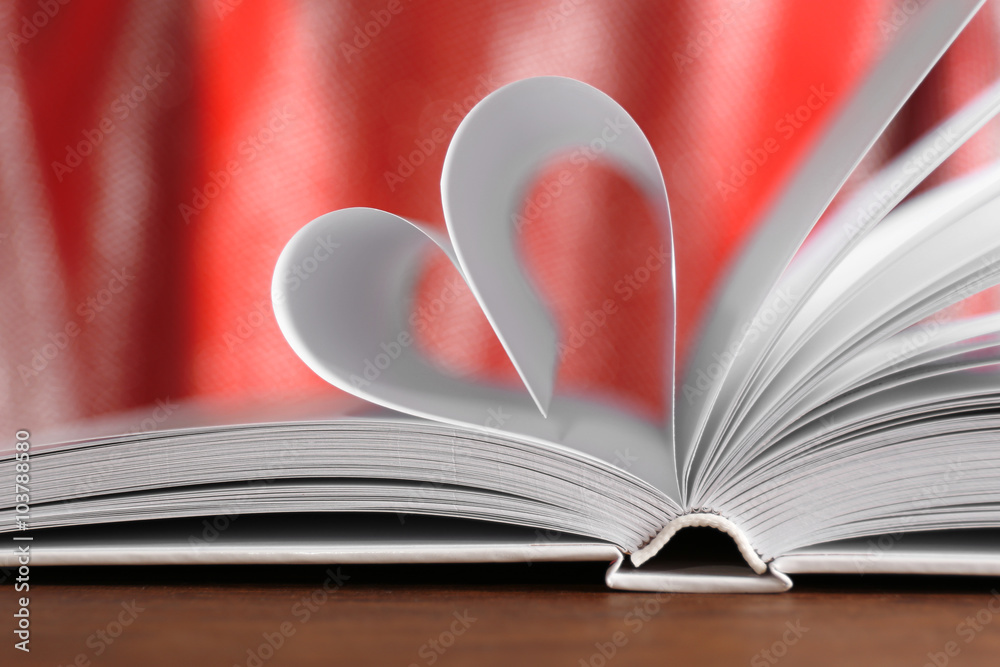 Heart from book pages on red blurred background Heart from book pages on red blurred background