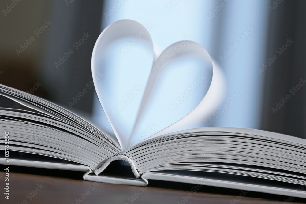 Heart from book pages on dark blurred background Heart from book pages on dark blurred background