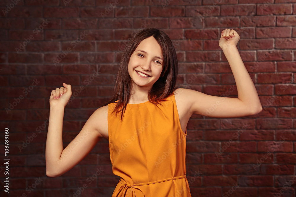 Beautiful young girl posing on brick background Beautiful young girl posing on brick background