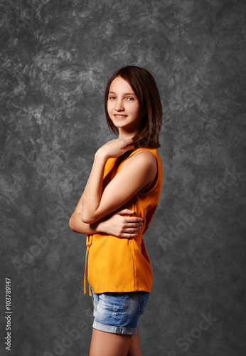 Beautiful young girl posing on gray background