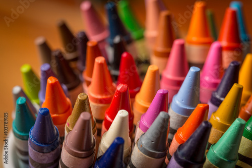Crayons standing in a mug against a wood background
