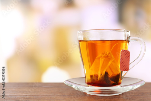 Glass cup with tea bag on wooden table, close up