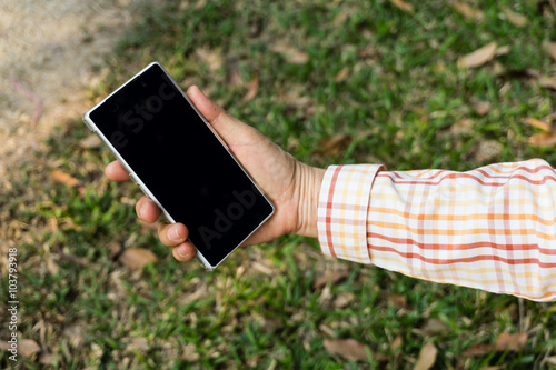 Woman using mobile smart phone in the park.