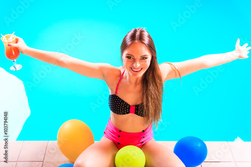 Happy woman with balloons and cocktail.