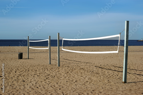 Volleyballfeld am Strand / Ein Beachvolleyballfeld mit einem Volleyballnetz am Strand von Long Beach mit Blick auf den Ozean. photo
