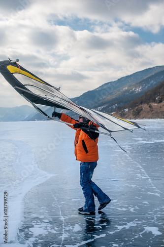 Man standing on ice with wing in the hands. photo