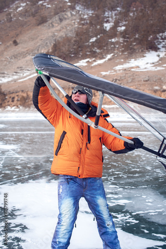 Man standing on ice with wing in the hands. photo