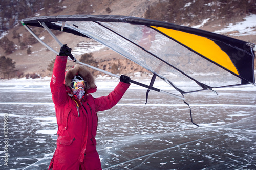 Woman standing on ice with wing in the hands. photo