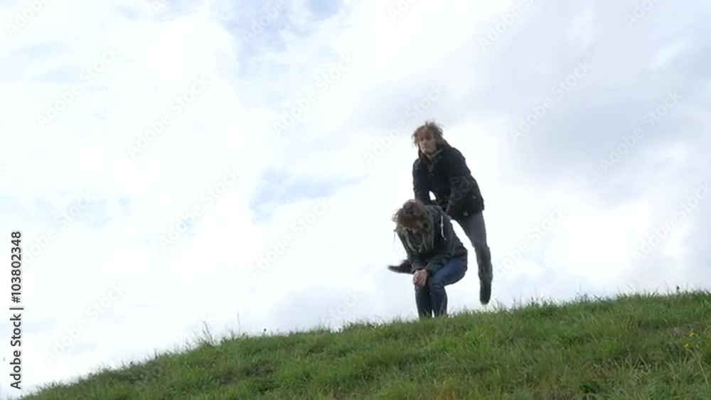 Two friends playing leapfrog, jumping down the hill Two friends playing leapfrog, jumping down the hill