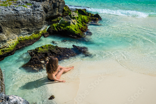 Obraz na płótnie Young fashion woman in bikini looking on sea at tropical beach. w salonie