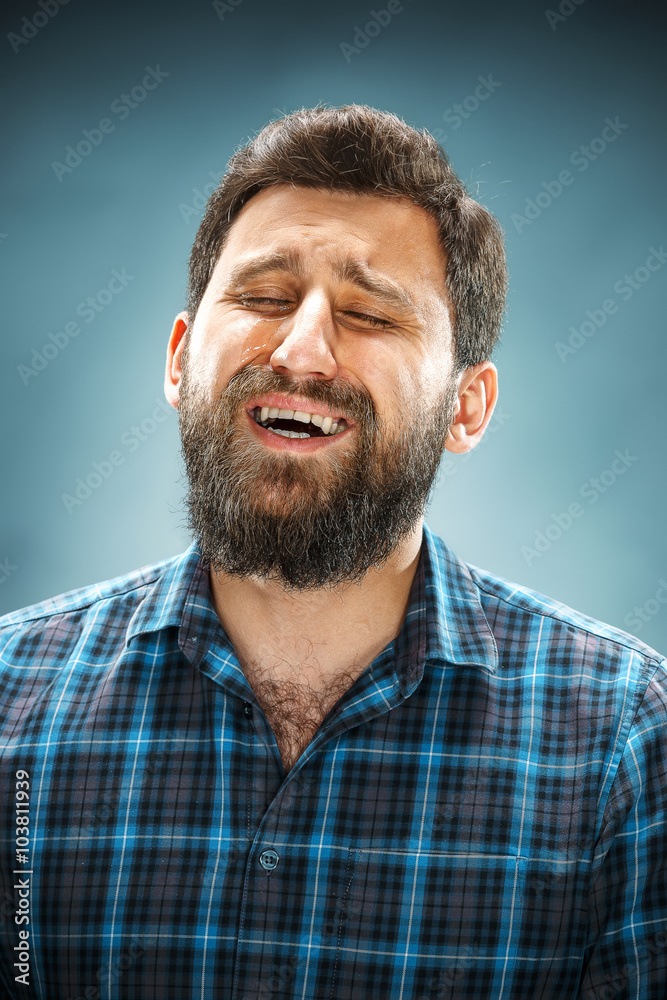 The crying man with tears on face closeup The crying man with tears on face closeup