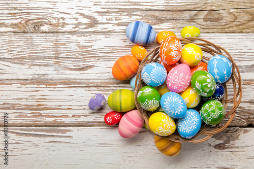 Easter eggs in basket placed on wooden planks