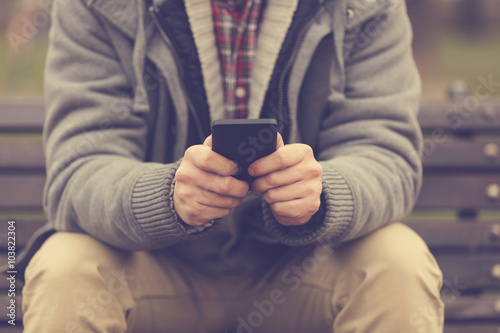 Modern guy typing on a smartphone.   © Kitja