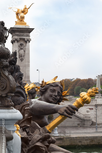 Sculpture in the Alexandre III bridge and Eiffel tower in Paris, France