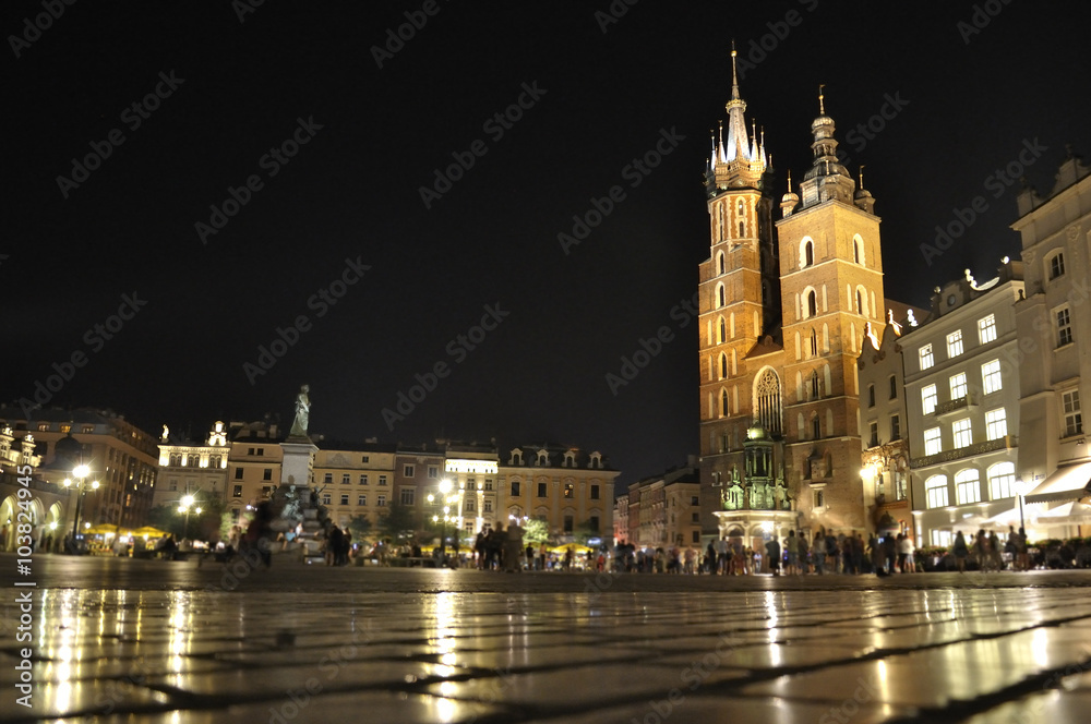View of the Main Market Square and St. Mary's Church at night located in Krakow, Poland